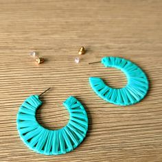 a pair of blue earrings sitting on top of a wooden table