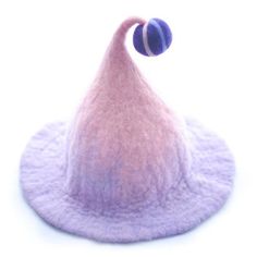 a pink and purple hat on top of a white surface with a ball in the middle