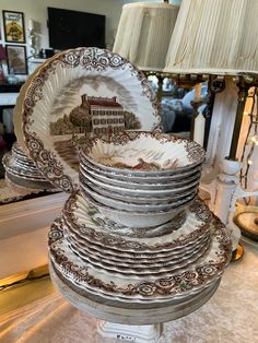 a stack of plates sitting on top of a table next to a lampshade