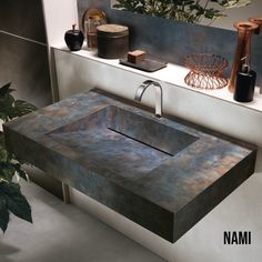 a bathroom sink sitting on top of a counter next to a potted green plant