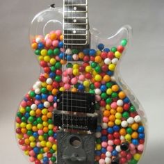 a guitar made out of candy balls and gummy on the top of it's neck