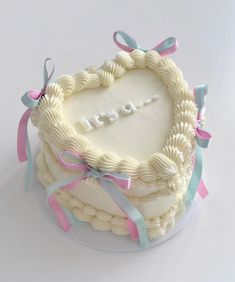 a heart shaped cake decorated with ribbons and bows