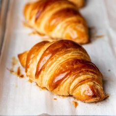 two croissants sitting on top of a baking sheet next to each other