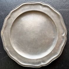 an antique silver plate on a black table