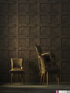 two chairs sitting next to each other in front of a wall