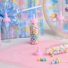 there are many candy in the bottles on the pink tablecloth and other items around it