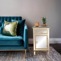 a living room with a blue couch and gold side table