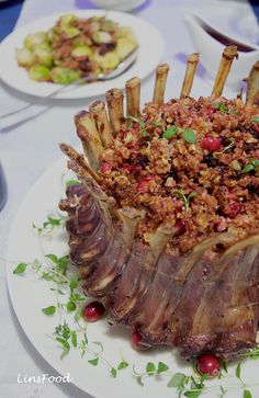 a large piece of meat is on a plate with other plates and utensils