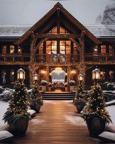 a large house covered in christmas lights and decorated with trees on the front porch is lit up at night