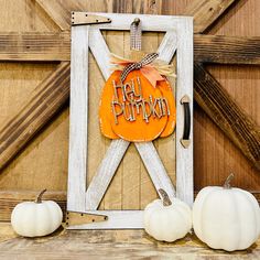 an orange pumpkin sitting on top of a wooden frame