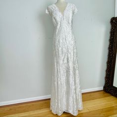 a white dress is on display in front of a mirror and a framed photo frame