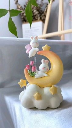 a small figurine is sitting on top of the moon with two little mice