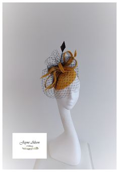 'Simple elegance is captured with this teardrop base in gold sinamay, which is adorned with bows and loops of sinamay bias and black crin.  Black veiling captures a mysterious look whilst a single arrow head feather reaches for the sky.  Sits on a headband This item has sold, however, similar pieces can be made in a variety of colours.  Please ask for details.  As every piece is handmade, some differences can occur from the photos listed on this site.  Made to order/bespoke/custom orders are non Elegant Gold Top Hat For Formal Occasions, Elegant Gold Fitted Top Hat, Elegant Gold Top Hat For Royal Ascot, Elegant Gold Top Hat For Church, Elegant Gold Top Hat For Party, Gold Curved Brim Top Hat For Party, Black Sinamay Fascinator For Wedding, Gold Curved Brim Costume Hat For Evening, Gold Top Hat For Kentucky Derby