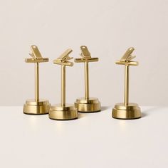 four gold - plated model airplanes are lined up in a row on top of each other