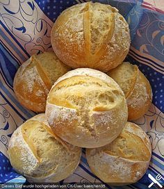 several loaves of bread sitting in a blue and white bowl