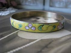 "A vintage Chinese yellow and white cloisonne bangle bracelet depicting beautiful flowers and foliage. It measures 3/8'' wide and 2 5/8'' across from side to side. Measures 8'' along the inside, so it will fit over any average hand. Stamped \"MADE IN REP. CHINA\" on the inside of the bangle. In very good condition." Vintage Bracelet Jewelry For Spring, Vintage Spring Bracelet Jewelry, Vintage Spring Jewelry Bracelet, Handmade Vintage Bracelets For Spring, Vintage Flower Bracelets For Spring, Hippie Goth, Asian Jewelry, Punk Vintage, Ear Piercing