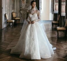 a woman in a wedding dress standing on a wooden floor