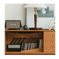 a book shelf with books, an amp and a lamp