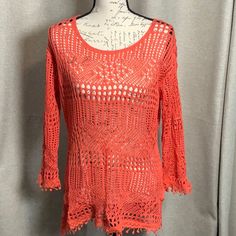 an orange crocheted top on a mannequin