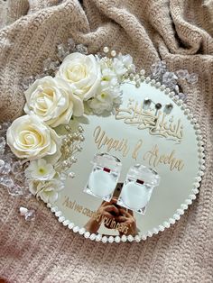 a couple of white roses sitting on top of a table next to a sign that says happily married