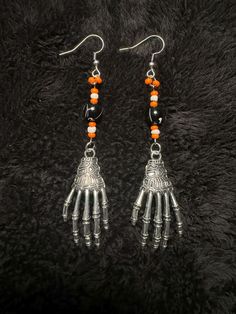 Embrace the spooky season with these Halloween dangling earrings that capture the essence of the holiday perfectly. Adorned with intricately designed skulls, pumpkins, cats, and bats, each earring tells a whimsical tale of Halloween folklore. The lightweight yet eye-catching design ensures comfort while making a bold statement. Whether you're dressing up for a costume party or simply adding a touch of Halloween spirit to your ensemble, these earrings are the ideal accessory. Let these festive earrings be your playful companion throughout the Halloween season, adding a touch of macabre charm to any outfit. Celebrate the magic of Halloween with these unique, themed earrings that are sure to turn heads and spark conversations wherever you go. Earrings are approximately 2.5" in total length. T Gothic Dangle Halloween Jewelry, Gothic Dangle Jewelry For Halloween, Gothic Nickel-free Halloween Earrings, Gothic Nickel Free Earrings For Halloween, Gothic Nickel-free Earrings For Halloween, Spooky Halloween Jewelry For Costume Party, Spooky Halloween Costume Party Jewelry, Halloween Dangle Metal Earrings, Halloween Dangle Pierced Earrings