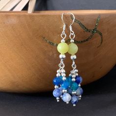 These yellow jade, blue agate and sodalite earrings were inspired by the colours of Cornwall. They are silver plated with 925 Sterling Silver hooks.  Drop length 5.8 cm Length from top of hook 6.6 cm Postage and Packaging: While the default P&P option is set to Royal Mail 2nd class signed delivery (£1.50), an upgrade to Royal Mail 1st class signed delivery (£1.95) is available to select from the checkout basket before checking out. The packaging is eco-friendly, without plastic, and consists of paper and cardboard materials. Customer Service: I prioritize providing attentive and personalized customer service. If you have any questions prior to placing an order or encounter any issues during your shopping experience, please contact or message me directly so that I can assist you. Additional Cheap Blue Earrings With Colorful Beads, Bohemian Blue Beaded Earrings With Natural Stones, Blue Round Beads Spiritual Earrings, Blue Beaded Earrings With Natural Stones, Multicolor Beaded Earrings With Natural Stones, Blue Spiritual Earrings With Round Beads, Spiritual Blue Earrings With Natural Stones, Boho Beaded Earrings, Yellow Accessories