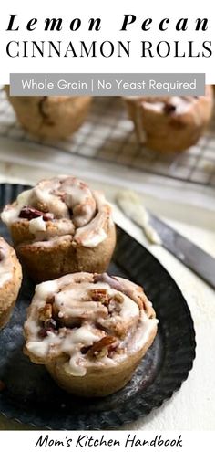 three cinnamon rolls sitting on top of a black plate