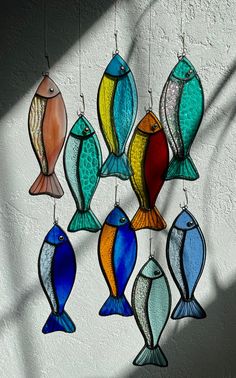 colorful glass fish hanging from hooks on a wall