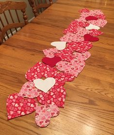 a long table with hearts cut out of it on top of the wooden floor next to chairs