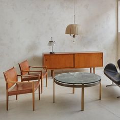 a living room filled with furniture next to a wall mounted lamp and a wooden cabinet