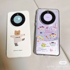 two cell phones sitting next to each other on top of a white surface with cartoon characters