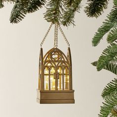 a christmas ornament hanging from a tree with lights in the window behind it