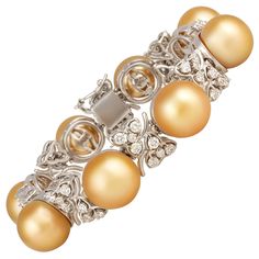 The golden South Sea pearl and diamond cuff bracelet features eight large pearls separated by eight floral motifs. The untreated pearls originate from the waters of Indonesia. They display a beautiful nacre and their natural color and high luster have not been enhanced in any way. The diameter ranges approximately between 14-14.5mm. The interspersed floral motifs are set with a total of 3.70 carats of round diamonds of top quality (F/G-VVS). The bracelet is one-of-a-kind. It was entirely handmad Diamond Cuff Bracelet, Gemstone Art, Golden South Sea Pearls, Tahitian Black Pearls, Antique Bracelets, Gold Bracelet Cuff, Sea Pearl, Elegant Bracelet, Exclusive Jewelry