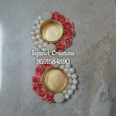 two vases with flowers and pearls on them sitting on a marble floor next to each other