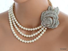 This glamorous necklace has been made with white Austrian pearls and a rose vintage inspired silver brooch with clear rhinestones. The inner strand measures about 17"  long and can be adjusted as it has an extender chain in the back. Pearls measure 8 mm in diameter in all strands.  Finished off with a silver hook and eye closure.    Brooch measures approximately 2 1/4" by 1 3/4" wide. Details, Brooch measures approximately 2 3/4" by 2 1/2" at it widest point. Austrian pearls measure 8mm. Inner strand measure approximately 17" long.  Outer strand measures about 20". **If your dress is ivory I recommend the white color in my opinion it is an off white and works with white and ivory gowns.  The cream works with cream, light cream and some champagne shades.  If you need help deciding the color Pearl White Flower Necklaces For Wedding, Silver Flower Pearl Necklace For Wedding, Statement Pearl Necklace, Wedding Pearl Necklace, Bridal Pearl Necklace, Pearl Necklace Wedding, Old Hollywood Glam, Pearl Bridal, Rose Vintage