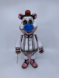 a toy mouse with a blue nose and hat on it's head is standing in front of a white background