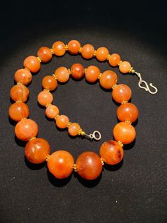 The beautiful orange color carnelian beads necklace from Himalaya Nepal This beads were used in prayer malas and used as jewelry and amulets in ancient times very smooth and shinny surface of this beads because of passage of time and usage of this beads in prayers mala and in necklace The age of this beads are more than 1000 years small size gold color brass beads are used as spacers in the necklace we provide fast and free shipping service to our customers by which can get the items by maximum Orange Carnelian Necklace In Spiritual Style, Orange Carnelian Round Bead Jewelry, Vintage Orange Gemstone Beads, Orange Carnelian Polished Beads Necklace, Round Orange Beads With Spiritual Style, Spiritual Round Orange Beads, Spiritual Orange Round Beads, Orange Carnelian Beaded Necklace With Large Beads, Orange Carnelian Beaded Necklaces With Large Beads