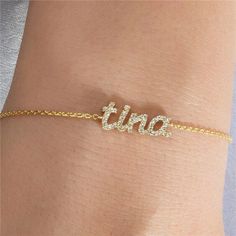 a woman's arm with a gold chain bracelet that says etra on it