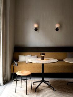 a table and two chairs in a room with light coming through the window on the wall