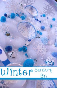 snowflakes, scissors and other items in a bowl with the words winter sensory bin