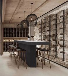 a bar with stools and wine bottles on the wall