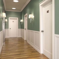 an empty hallway with green walls and white trim on the doors, wood floors and hard wood flooring