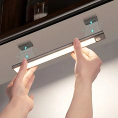 two hands are holding the light bar in front of a mirror