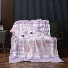 a pink teddy bear blanket sitting on top of a wooden floor