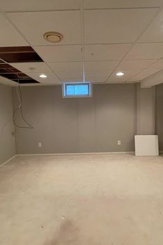 an empty room with no one in it and some wires hanging from the ceiling above