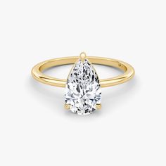 a pear shaped diamond engagement ring in yellow gold