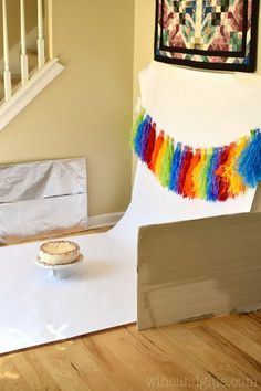 a cake sitting on top of a table in front of a white backdrop and stairs