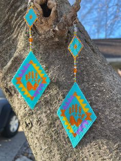 a pair of earrings hanging from a tree