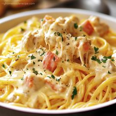 a white plate topped with pasta covered in chicken and cheese sauce, garnished with parsley