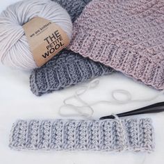 three crocheted hats and two knitting needles